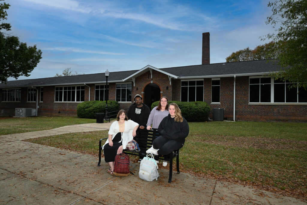 Four students outside of a building on campus