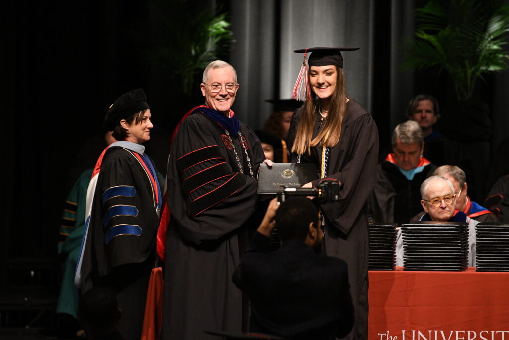 UWA President Dr. Ken Tucker presents diploma to graduate