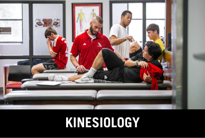 Click here to donate to the Department of Kinesiology. Image of student athletic trainer practicing on student athlete